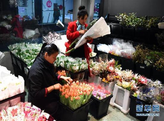 臧晶晶(左)在河南郑州小马进口鲜花店整理郁金香(11月7日摄)。 新华社记者李嘉南摄