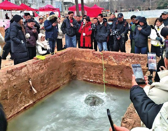 笼罩泉眼的机井房已被拆除，市民围观贾鲁河源头温泉。