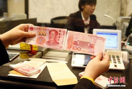 11月12日，北京市交通银行内，一名市民一口气换出了2万元新版100元人民币。中新社记者 张浩 摄