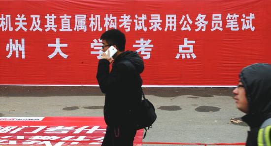 一名考生从公务员考点条幅前走过