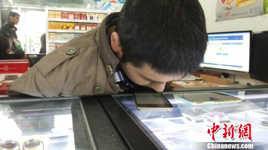 沒有了雙臂，李怡瀟學會用身體的任何部位來輔助自己的生活。圖為李怡瀟用鼻尖加微信好友。　滄海　攝