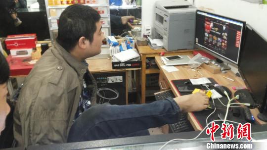 11年來，李怡瀟練就了一雙靈巧的雙腳，不僅能生活自理，還能操作電腦，靠一雙腳經營著小店，維持著一家人的生活。　滄海　攝