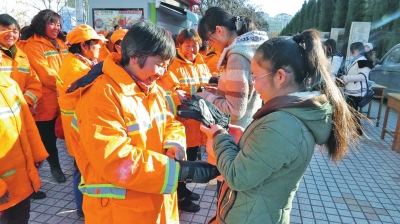 戴上學生們贈送的手套，環(huán)衛(wèi)工人很開心。