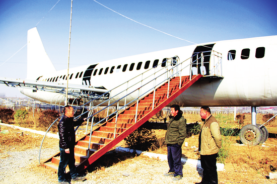 王蘭群（左一）向參觀者介紹自己制造的“大型客機”