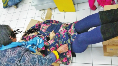 在郑州某商场，一位年轻女子晕倒在地，郑州民间公益救援队的冯海河帮忙施救。