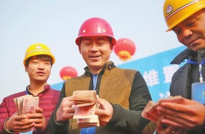 领到工钱后,他们乐开了花。记者王亚鸽摄影