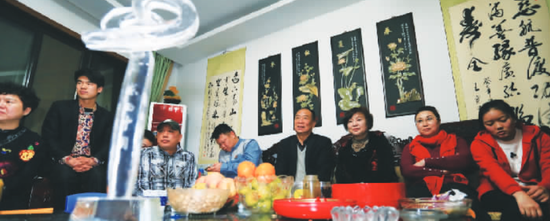 获得“感动中国”年度人物的王宽(右四)和家人在收看颁奖典礼