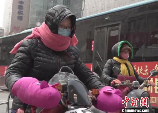 3月8日以来，郑州大风降温，出行市民无奈又裹上了厚厚的冬装。　阚力　摄
