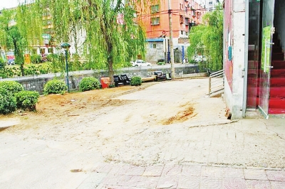 曾被挖开的地面回填后,痕迹依旧清晰可见，距离两层小楼约1米。