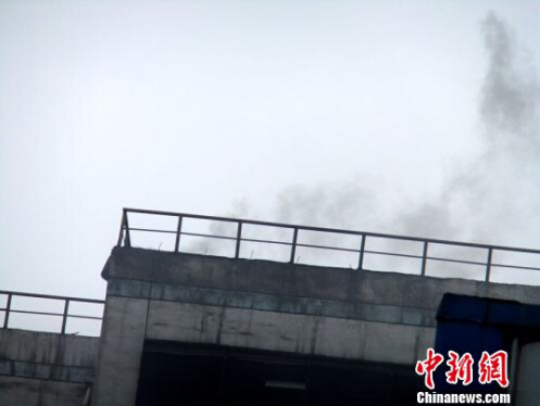 黑煙在天空中被風(fēng)吹散，漸漸變淡?！菗P(yáng) 攝