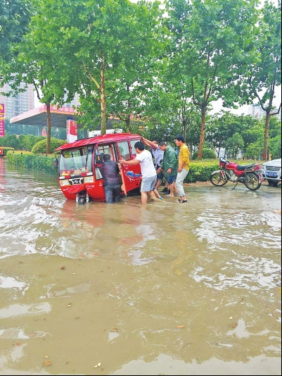 热心市民蹚水帮助老人推车