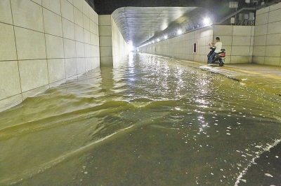 红专路下穿隧道积水,非机动车只能绕行人行道。