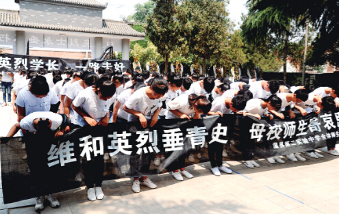 母校温县实验二中师生为烈士鞠躬送行。 
