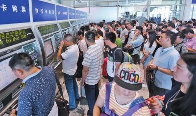 郑州东站3楼候车厅自动取票售票机前排队的人很多
