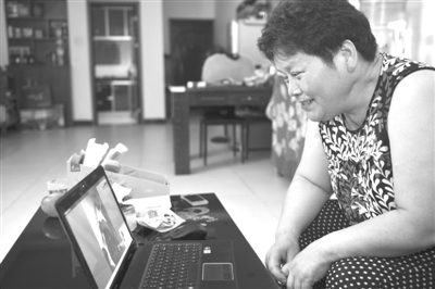 在长沙家中,蒋美华通过笔记本电脑与妹妹视频通话 长沙晚报记者 王志伟 摄