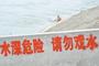 男子大白天在河边警示牌旁裸洗 称没钱去澡堂