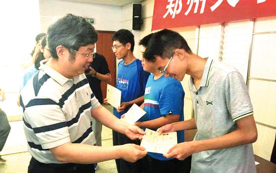 中国工程院院士、郑州大学校长刘炯天为新生颁发入学通知书