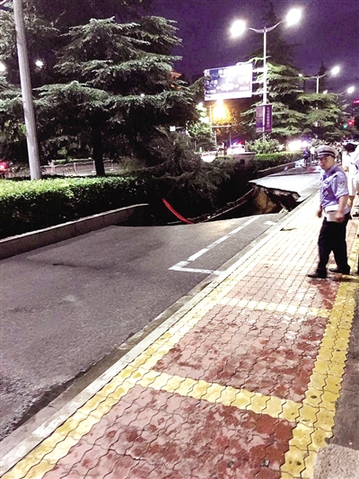 暴雨中道路塌方，有行人坠入坑中