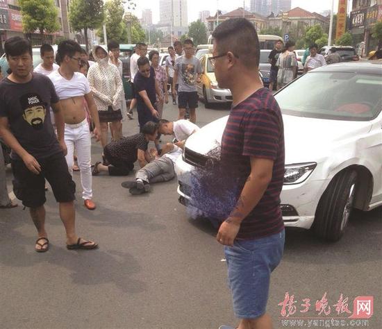 一对老夫妇遇车祸卷入车底,众人合力抬车救人