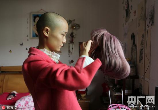 黃文霞在梳理假發，化療后，小霞的頭發幾乎掉光，她在剃成光頭前準備好假發，一共買了三頂。