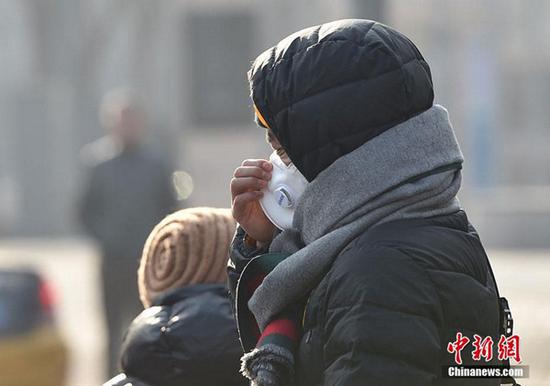 昨天，北京霾持续，市民戴口罩“全副武装”出行。图片来源：中新网