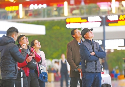 一些抱着希望的旅客，守在信息屏前等待航班恢复正常。