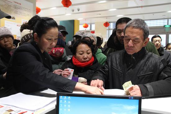 安阳市民正在邮政营业厅购买鸡年生肖邮票（张月 摄）