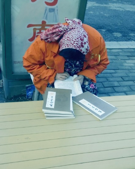 鄭州街頭環衛工大姐忘我讀書