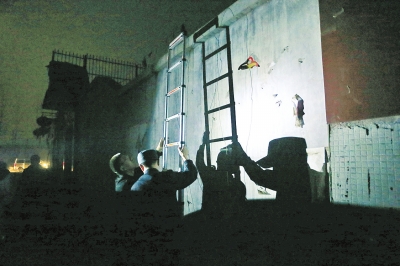 干警们迅速打开便携式云梯，准备翻墙进入抓“老赖”。