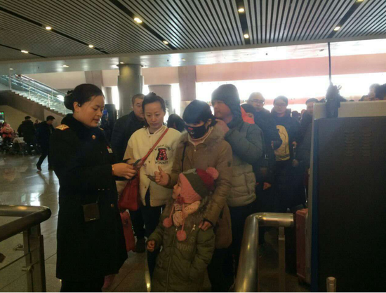 高鐵新鄉(xiāng)東站客運員在人工檢票口檢票。