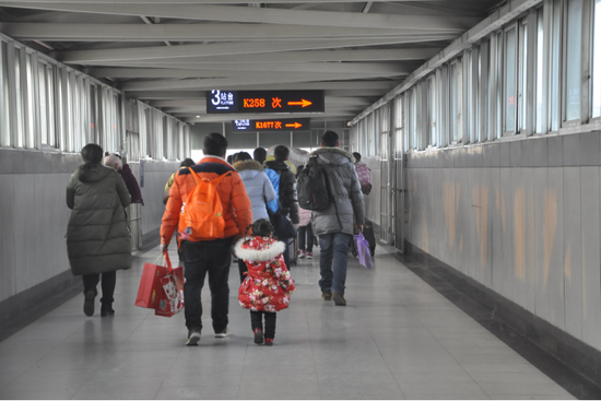 新鄉車站進站天橋內步履匆匆的旅客。