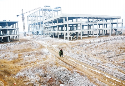 雖然工資沒結(jié)，彭幫金還是穿著軍大衣一如既往地在雪后的工地巡邏。
