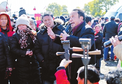 民間藝人唱得投入，周圍觀眾聽得認真。