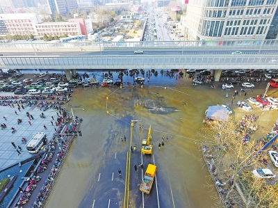 昨日下午2時許，鄭州市花園路與農業路路口東南角自來水管道爆裂，形成大片積水，造成車輛和行人擁堵約1小時。記者白周峰　洪波攝影
