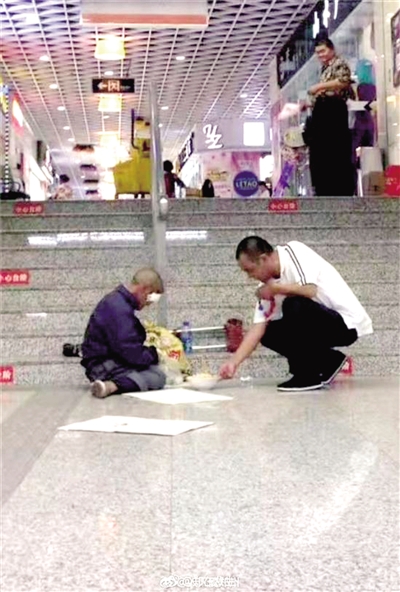 地铁站口一名男子将一碗捞面放在流浪汉面前（图片来自微博网友）