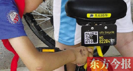 一名小學生正在手動破解一輛“小黃車”的密碼鎖