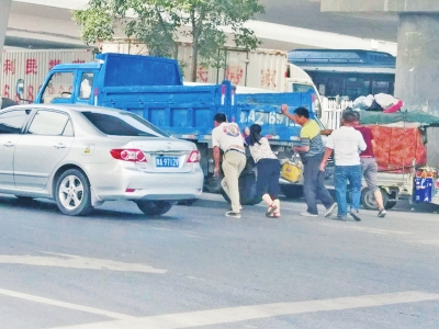 郑州街头货车抛锚 等活农民工帮忙推车