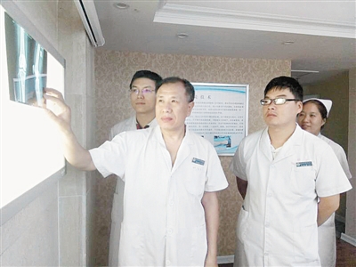 市骨科医院运动医学关节微创科主任谢学然（左）在研究病案