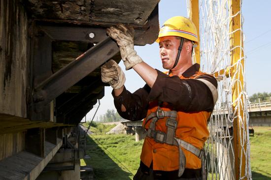 9月7日，南阳工务段南阳桥梁车间职工悬在“半空”中进行桥梁维修作业。