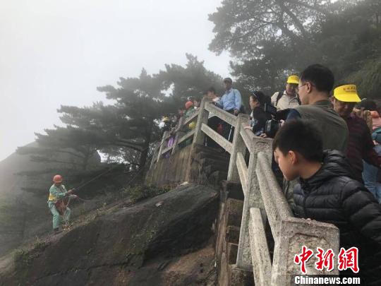 李培生在悬崖上拾捡垃圾，受到游客关注 侯晏 摄