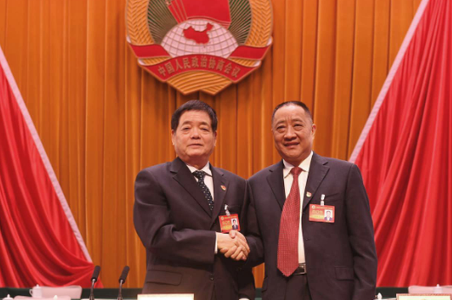 十三届市政协主席王璋（左）和十四届市政协主席黄保卫（右）亲切握手