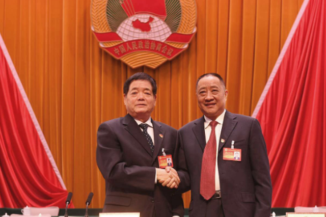 十三届市政协主席王璋(左)和十四届市政协主席黄保卫(右)亲切握手