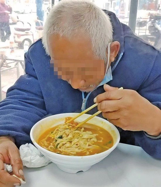 老人正在吃张梦香为他点的热汤面