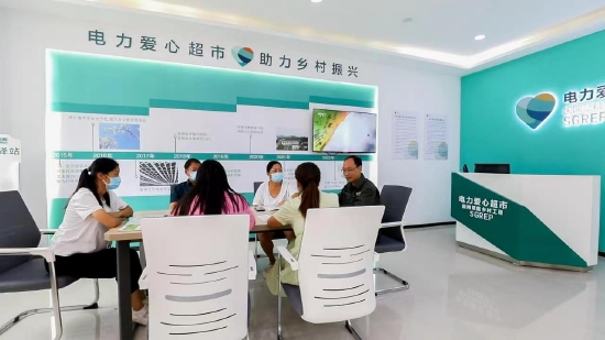 国网河南电力驻村第一书记王修庞向村民介绍“电力爱心超市”积分兑换规则。何艳 摄