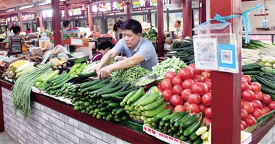 市民在农贸市场内选购蔬菜瓜果 记者 丁友明 图