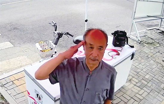 一位大爷向镜头敬礼（爱心冰柜监控截图）