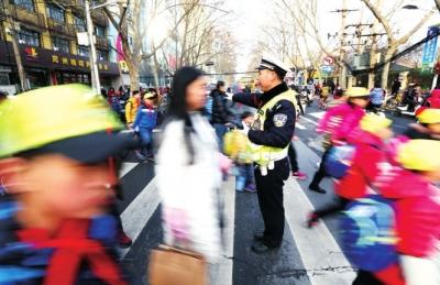 为了预防堵车，民警在伊河路小学门口指挥交通。