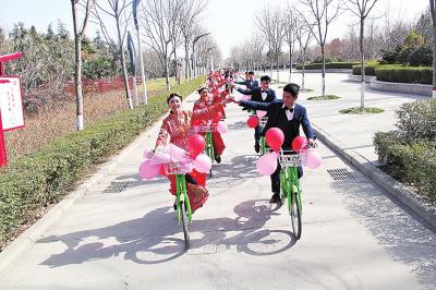 商丘举行零彩礼集体婚礼 10对新人骑自行车绕