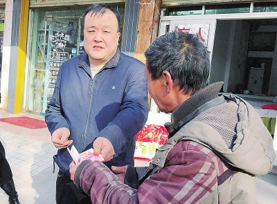 除了米面油,周小力(左一)还给每个贫困户塞了200元钱。
