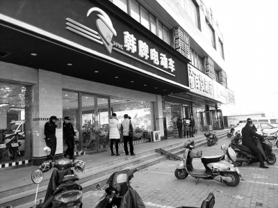 市民聚集在和平车行店前要说法,民警赶到后对店铺进行了查封。